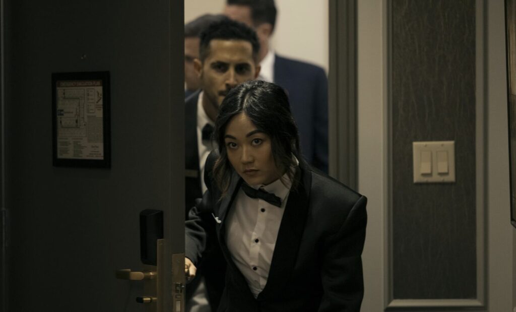 Frenchie and Kimiko in tuxes entering a hotel room.